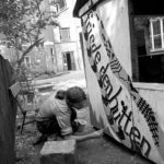 Christian Halbrock, Oppositioneller in der DDR und Mitbegründer der Umwelt-Bibliothek, malt ein Transparent für den Frieden, Friede den Hütten, im Hinterhof des Gemeindehauses in der Griebenowstraße 16.  ©Ann-Christine Jansson